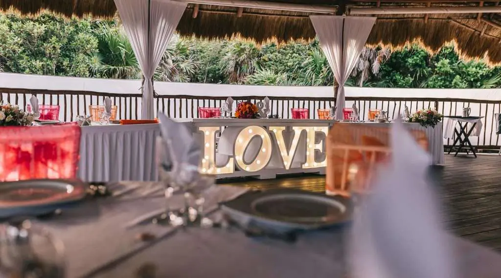 a wedding reception set up with a love sign on the table.